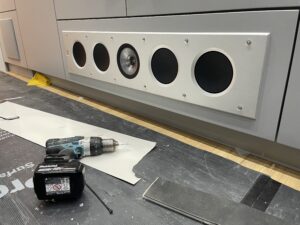 the KEF Ci Speakers being installed into the bespoke cabinet, 